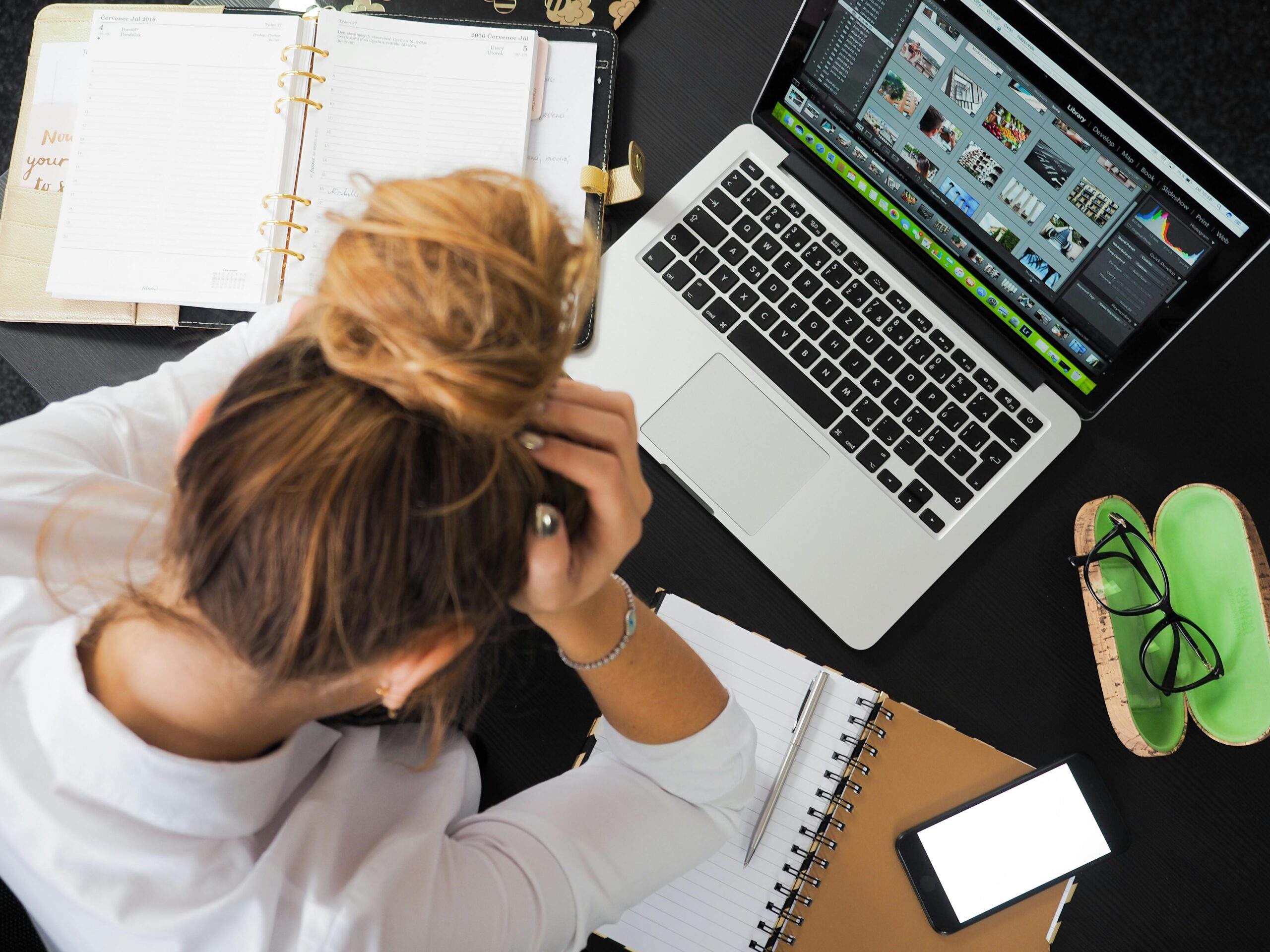 frustrated woman laptop paperwork overwhelmed