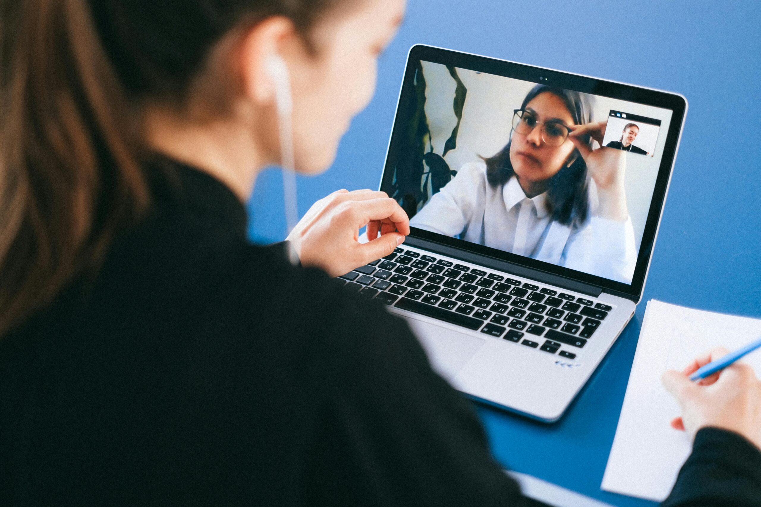 Female practitioner focused during a calm video session at a tidy desk